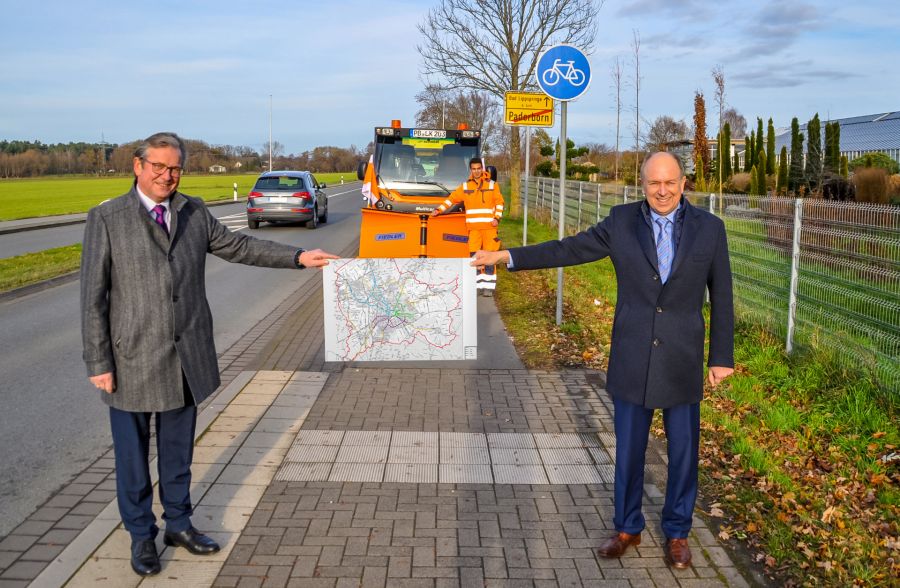 Teilen sich den Winterdienst für Radwege auf allen Hauptpendler-Routen auf – Bürgermeister Michael Dreier und Landrat Christoph Rüther. Im Hintergrund: Bastian Barisch vom Kreisstraßenbauamt mit einem Multicar.    Foto: Kreis Paderborn, Michael Rüngeler